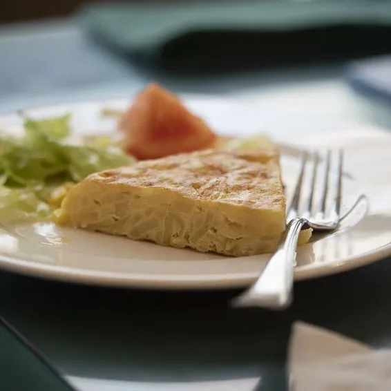 Plato de tortilla de patata con ensalada servido en la residencia Neurocare Home Mieses Valladolid